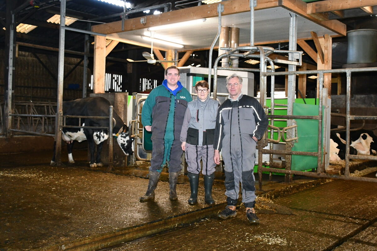Des agriculteurs dans un bâtiment avec une vache qui entre dans un robot de traite - Illustration Une nouvelle dynamique avec la robotisation