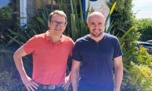 2 hommes devant une maison