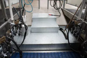 Des escaliers au fond d'une salle de traite