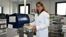 Une femme tient un panier d'échantillons dans un laboratoire