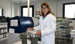 Une femme tient un panier d'échantillons dans un laboratoire