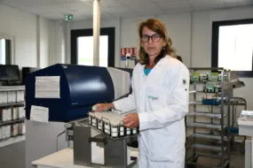 Une femme tient un panier d'échantillons dans un laboratoire
