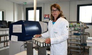 Une femme tient un panier d'échantillons dans un laboratoire