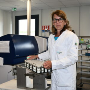 Une femme tient un panier d'échantillons dans un laboratoire