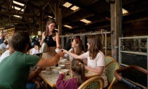 Un groupe de personnes en train de petit déjeuner dans une stabulation pour vaches laitières