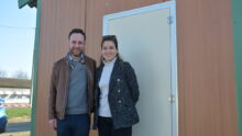 Un couple devant la porte d'un poulailler