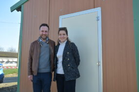 Un couple devant la porte d'un poulailler