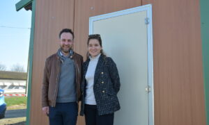 Un couple devant la porte d'un poulailler