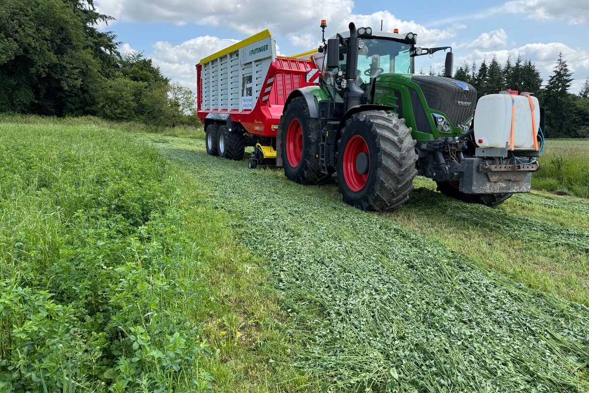 Un tracteur équipée d'un remorque autochargeuse dans une parcelle de luzerne - Illustration Aujourd’hui 30 ha de luzerne, plus demain ?
