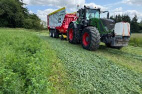 Un tracteur équipée d'un remorque autochargeuse dans une parcelle de luzerne
