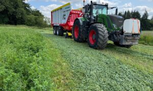 Un tracteur équipée d'un remorque autochargeuse dans une parcelle de luzerne
