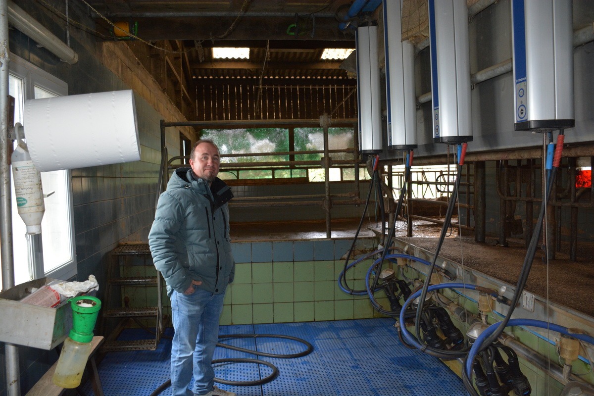 Un homme dans une salle de traite - Illustration Sobriété énergétique et autonomie : un défi au quotidien