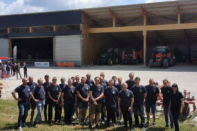 Des agriculteurs devant un bâtiment avec des tracteurs