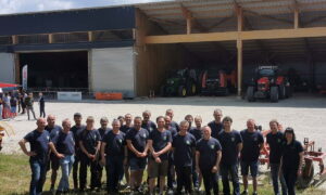 Des agriculteurs devant un bâtiment avec des tracteurs