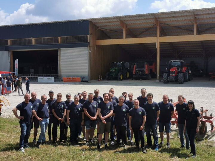 Des agriculteurs devant un bâtiment avec des tracteurs