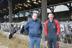 un éleveur et son technicien devant la stabulation laitière