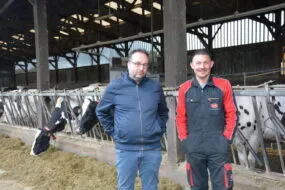 un éleveur et son technicien devant la stabulation laitière