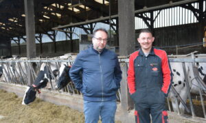 un éleveur et son technicien devant la stabulation laitière