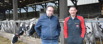 un éleveur et son technicien devant la stabulation laitière