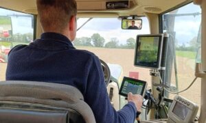 Un homme de dos dans une cabine de tracteur