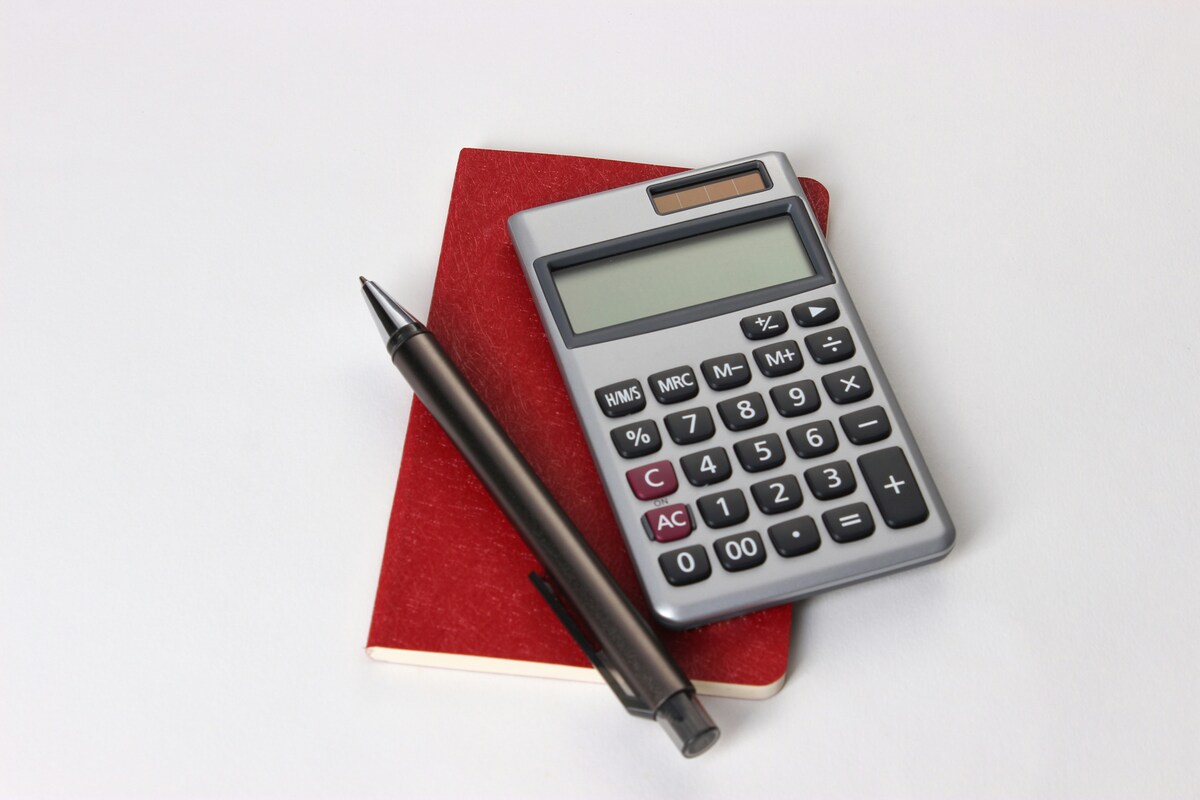 Un carnet, un crayon et une calculatrice posés sur une table blanche - Illustration Comptabilité, des règles  en mutation