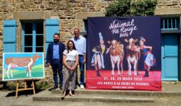 Des personnes posent à côté de l'affiche du National Pie Rouge 2026