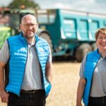 Deux personnes devant des remorques agricoles
