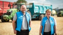 Deux personnes devant des remorques agricoles