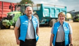 Deux personnes devant des remorques agricoles