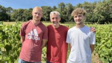 Trois personnes dans un champ de vignes