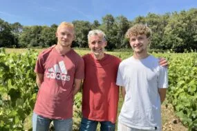 Trois personnes dans un champ de vignes