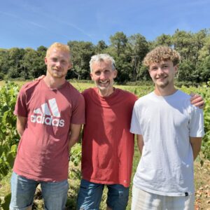 Trois personnes dans un champ de vignes
