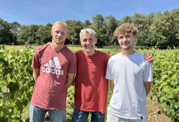 Trois personnes dans un champ de vignes