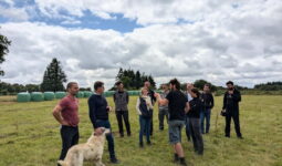 Un groupe de personne dans un champ avec un chien de protection