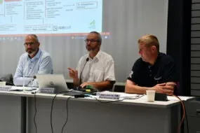 trois hommes à une tribune