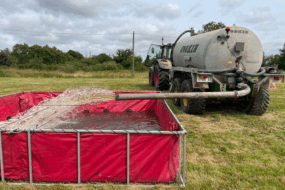 Une tonne à lisier remplit d'eau approvisionne une réserve installée par les pompiers.