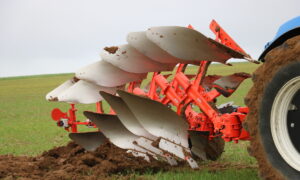 Gros plan dans un champ sur une charrue attelée à l'arrière d'un tracteur