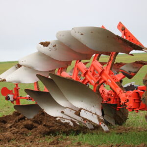 Gros plan dans un champ sur une charrue attelée à l'arrière d'un tracteur