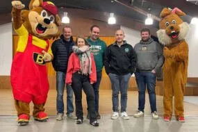 Deux mascottes avec quatre hommes et une femme.