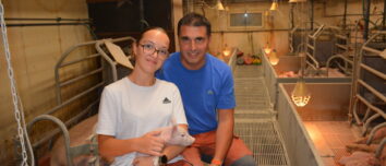 Un homme et une jeune fille souriants dans un élevage de porc