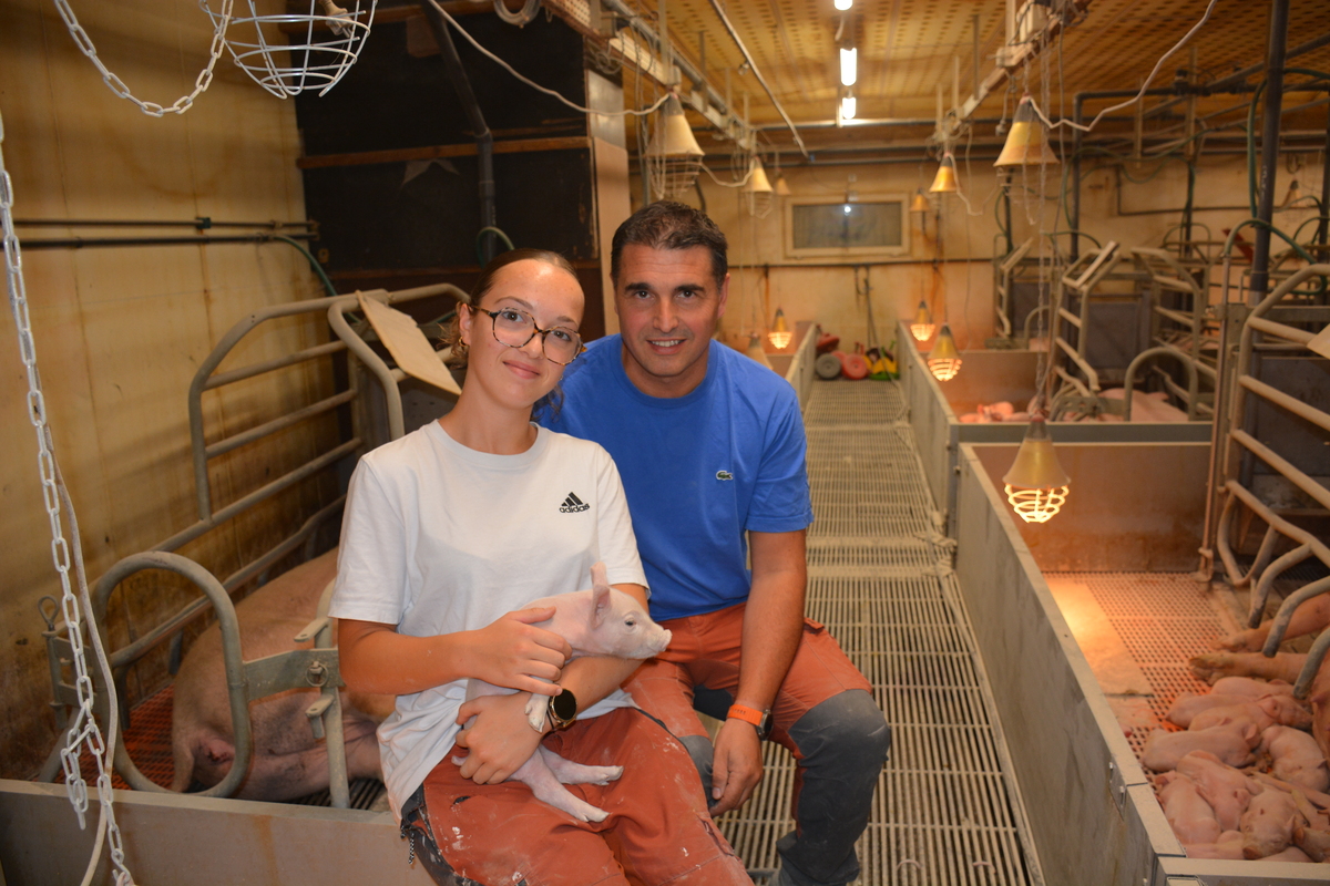 Un homme et une jeune fille souriants dans un élevage de porc - Illustration Parcours : De la plume à la soie