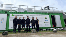Un groupe de personne devant une unité d'élimination de méthane dans l'air en milieu agricole