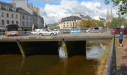 Un pont au dessus d'une rivière avec des voitures qui roulent dessus