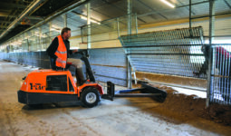 Un homme sur un engin dans un bâtiment d'élevage de volailles