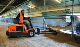 Un homme sur un engin dans un bâtiment d'élevage de volailles