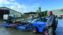Un homme devant une machine pour rammasser les poulets.