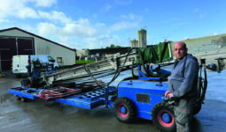Un homme devant une machine pour rammasser les poulets.