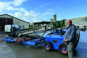 Un homme devant une machine pour rammasser les poulets.