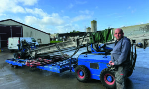 Un homme devant une machine pour rammasser les poulets.