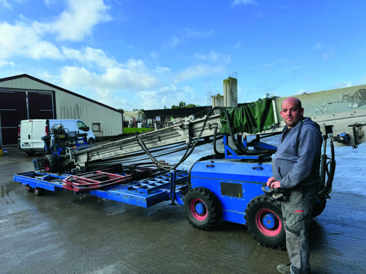 Un homme devant une machine pour rammasser les poulets.